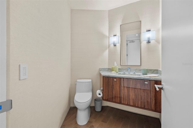 bathroom with hardwood / wood-style floors, vanity, and toilet