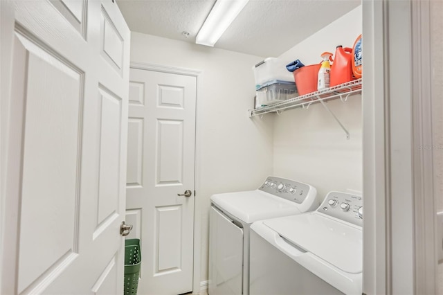 laundry room featuring laundry area, separate washer and dryer, and a textured ceiling