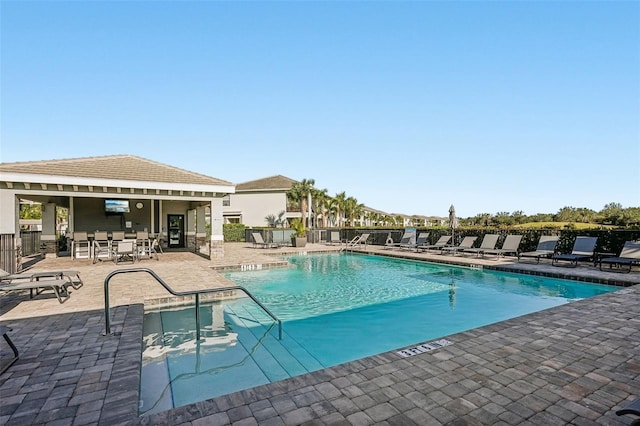 community pool featuring a patio and fence