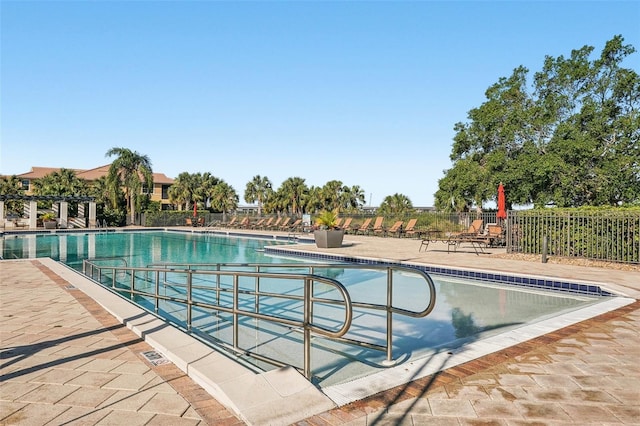 community pool featuring a patio area and fence