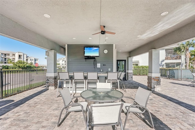 view of patio featuring ceiling fan, fence, and outdoor dining space