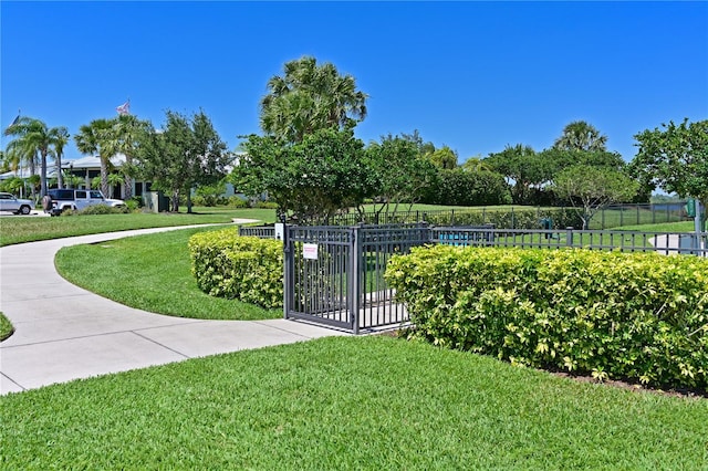 surrounding community featuring a gate, fence, and a yard