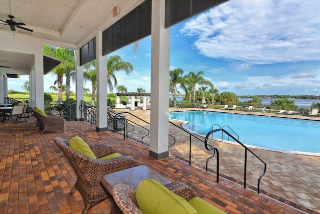 view of swimming pool with ceiling fan and a patio