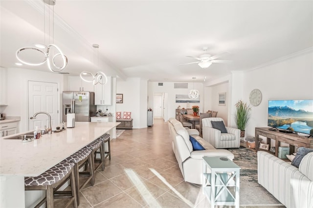 living room featuring light tile patterned floors, crown molding, visible vents, and a ceiling fan