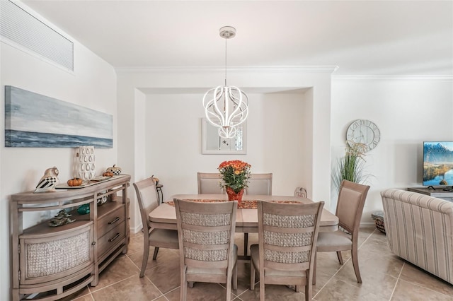 dining area featuring ornamental molding, light tile patterned flooring, and an inviting chandelier