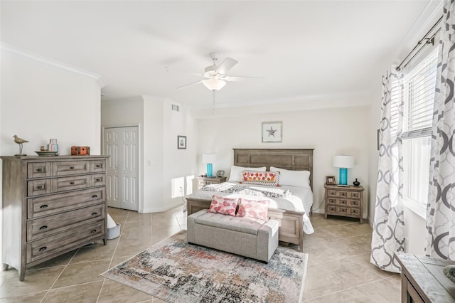 tiled bedroom featuring a closet, ceiling fan, and crown molding