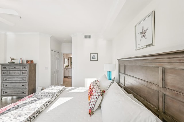 bedroom featuring ensuite bathroom, a closet, and ornamental molding