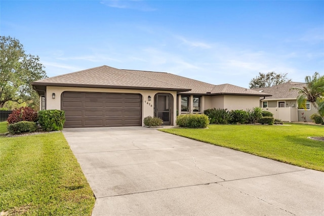 single story home featuring a garage and a front lawn