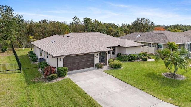 ranch-style home with a garage, a front yard, and central AC unit