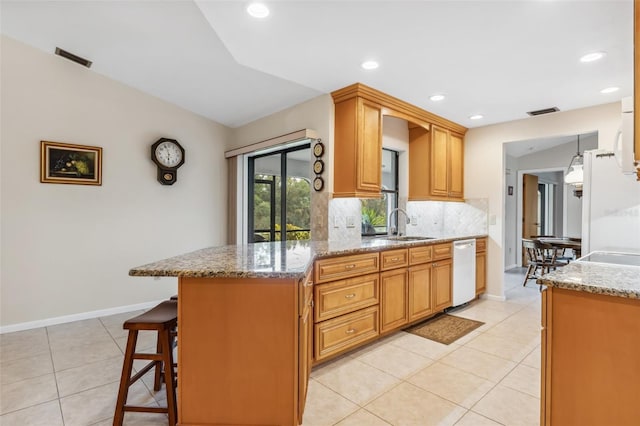 kitchen featuring light stone countertops, white appliances, decorative backsplash, sink, and light tile patterned floors