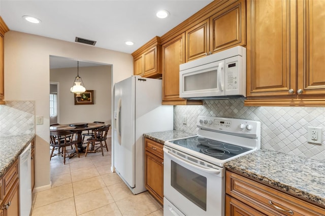 kitchen with decorative light fixtures, tasteful backsplash, light stone counters, light tile patterned flooring, and white appliances