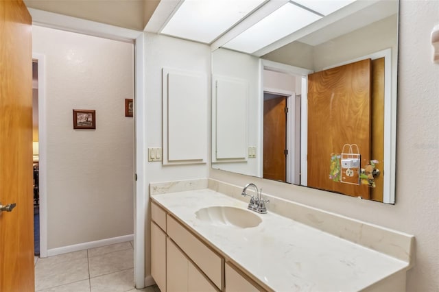 bathroom featuring tile patterned floors, a skylight, and vanity