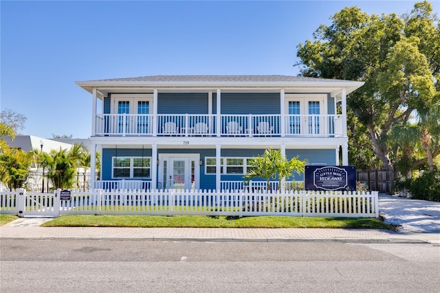 view of front of property featuring a balcony and french doors