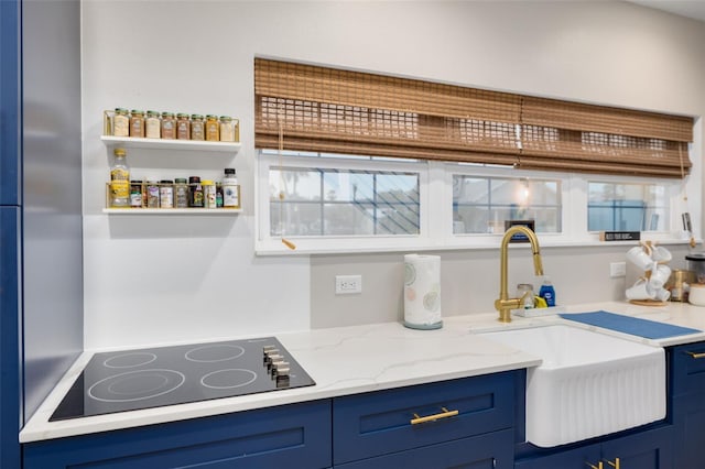 719 Douglas Ave, Dunedin, FL 34698 - kitchen featuring a sink, black electric cooktop, blue cabinets, and light stone counters