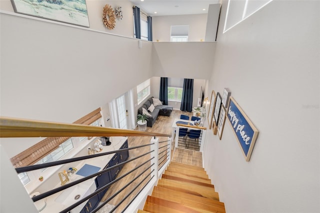 stairway featuring a high ceiling and hardwood / wood-style flooring