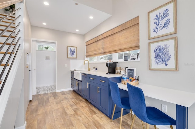 kitchen featuring a kitchen breakfast bar, a healthy amount of sunlight, built in desk, and light hardwood / wood-style flooring