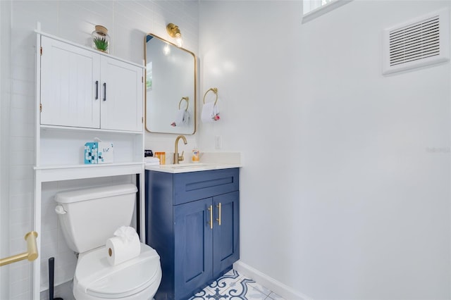 bathroom with tile patterned floors, vanity, toilet, and tile walls