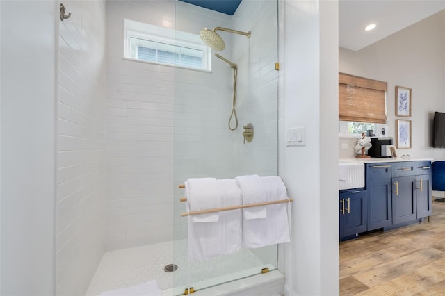 bathroom featuring wood-type flooring and a tile shower