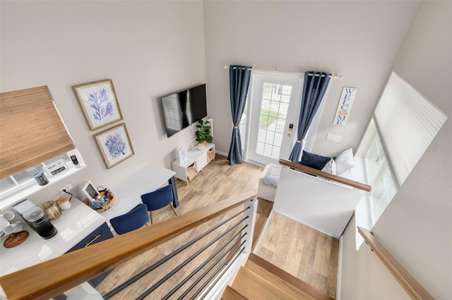 interior space featuring a towering ceiling and light hardwood / wood-style flooring