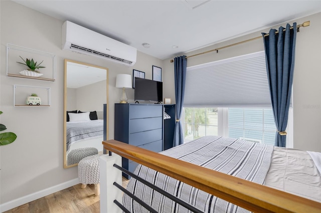 bedroom with a wall unit AC and hardwood / wood-style flooring