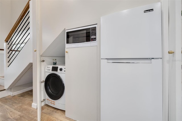 washroom with washer / dryer and light wood-type flooring