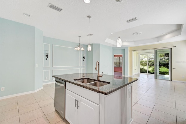 kitchen featuring dishwasher, sink, an island with sink, decorative light fixtures, and white cabinetry