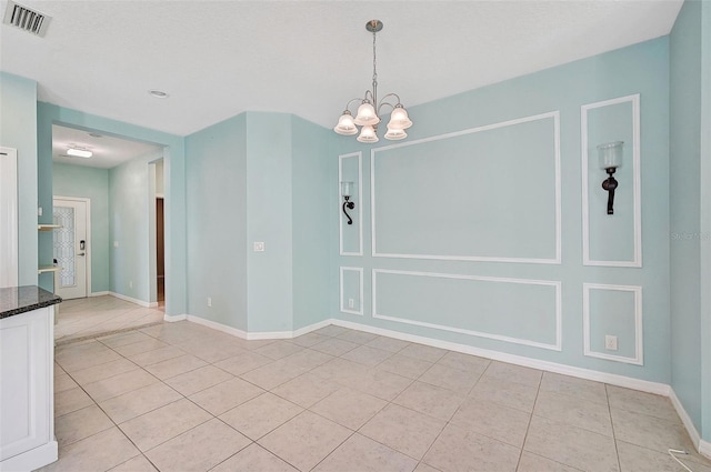 unfurnished dining area with light tile patterned floors and a notable chandelier