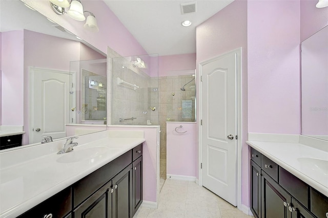 bathroom featuring a tile shower, tile patterned floors, and vanity