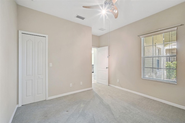 carpeted spare room featuring ceiling fan