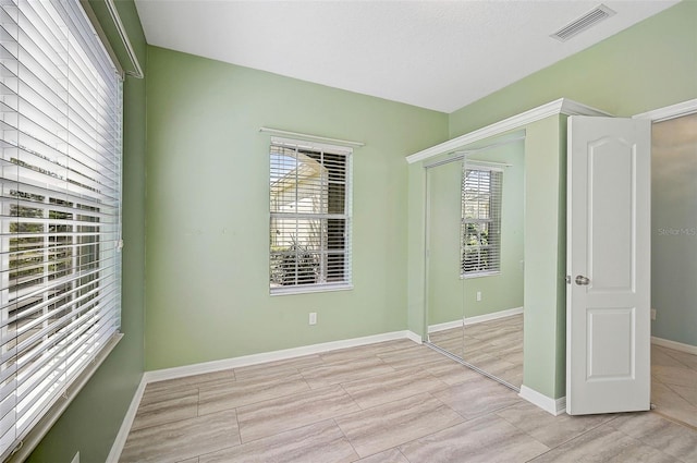 unfurnished bedroom featuring light hardwood / wood-style flooring and a closet