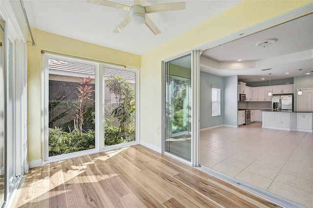 unfurnished sunroom with ceiling fan