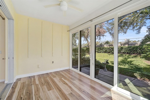 unfurnished sunroom featuring ceiling fan