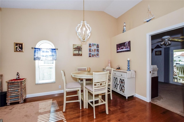 dining space with lofted ceiling, dark hardwood / wood-style floors, and ceiling fan with notable chandelier