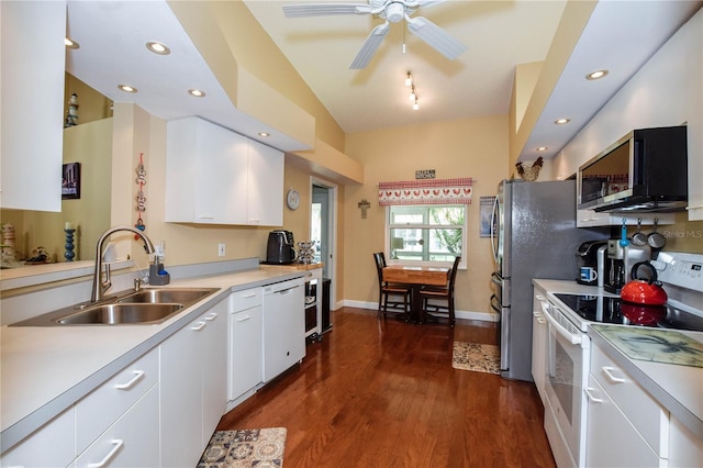 kitchen with dark wood-type flooring, sink, ceiling fan, white appliances, and white cabinets