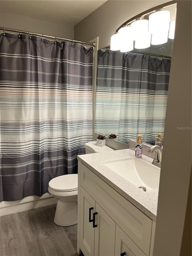 bathroom with walk in shower, wood-type flooring, toilet, and vanity