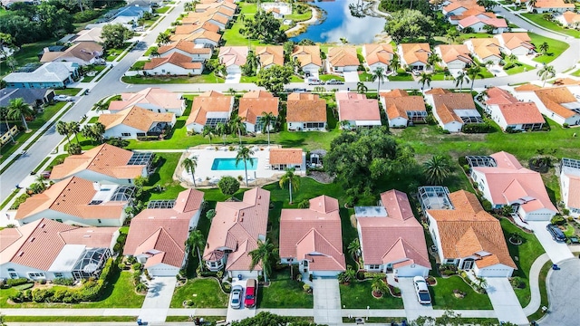 aerial view of property and surrounding area with nearby suburban area, a pool area, and a large body of water