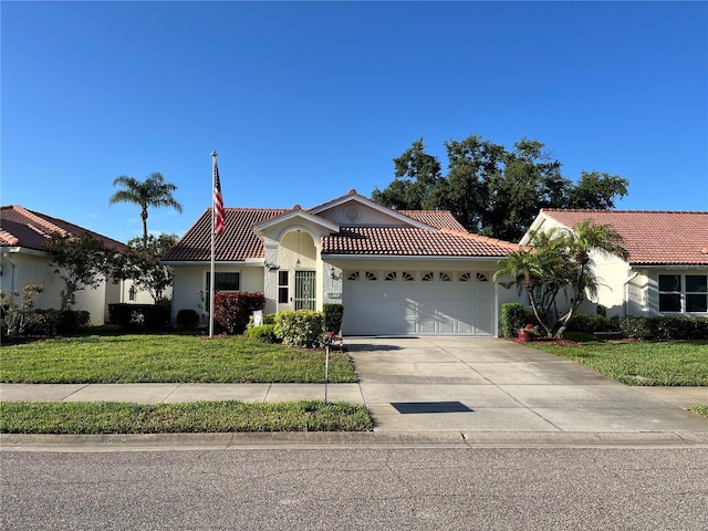 view of front facade with a tile roof, an attached garage, concrete driveway, a front lawn, and stucco siding