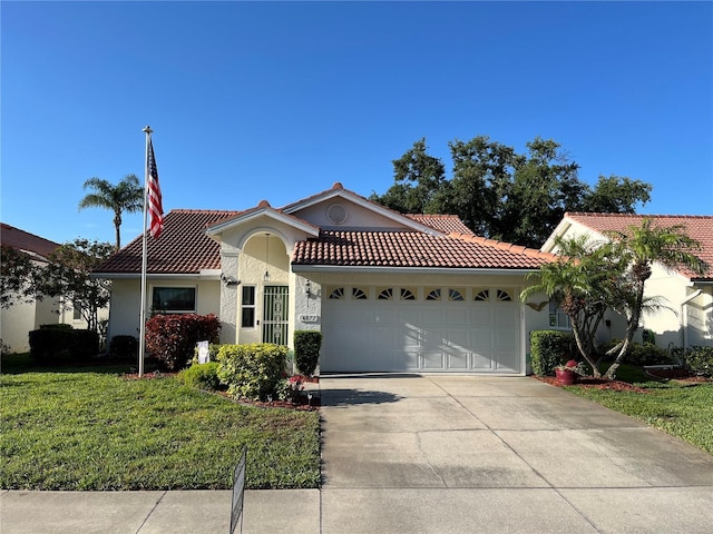 mediterranean / spanish house featuring a tiled roof, concrete driveway, stucco siding, an attached garage, and a front yard