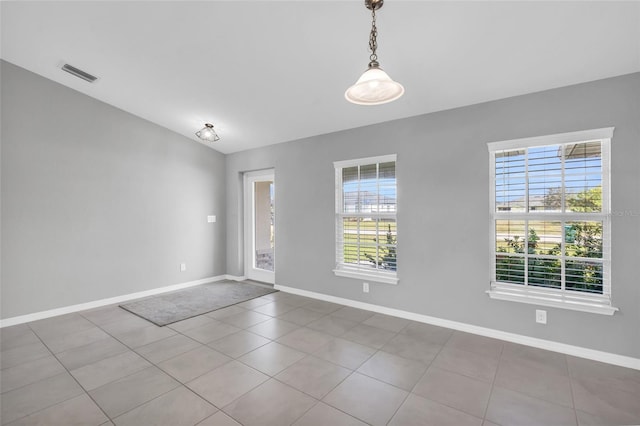 unfurnished room with tile patterned flooring and plenty of natural light