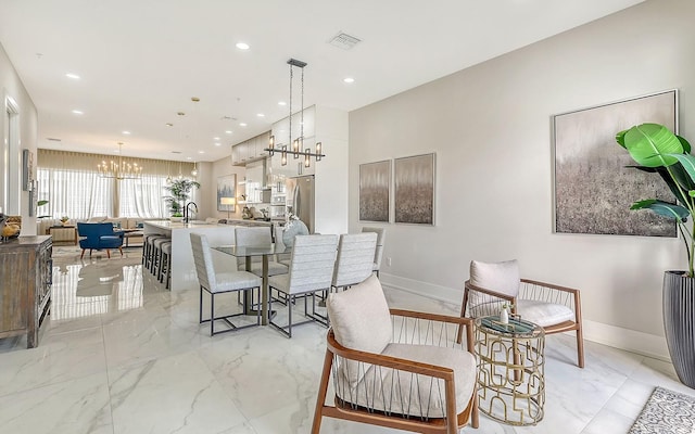 dining area with sink and an inviting chandelier