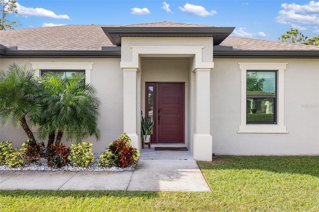 view of exterior entry featuring a yard