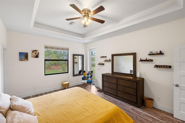 bedroom featuring a tray ceiling, ceiling fan, and hardwood / wood-style flooring