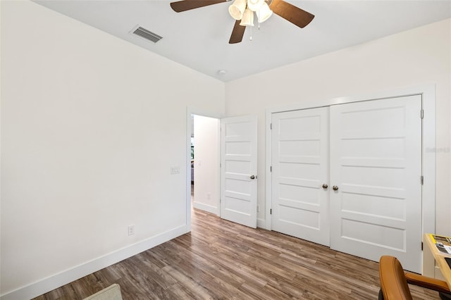 unfurnished bedroom featuring a closet, ceiling fan, and hardwood / wood-style floors