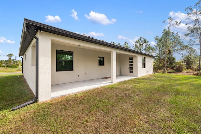 rear view of house featuring a patio area and a yard