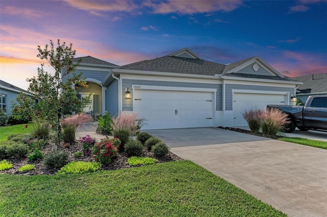 ranch-style home with a garage and a lawn