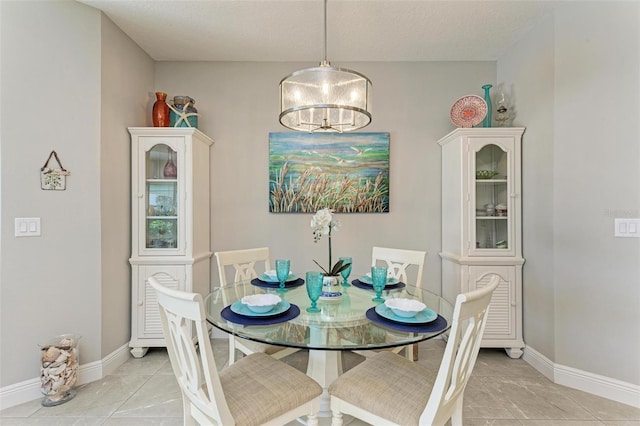 dining area featuring a textured ceiling, a chandelier, and light tile patterned flooring