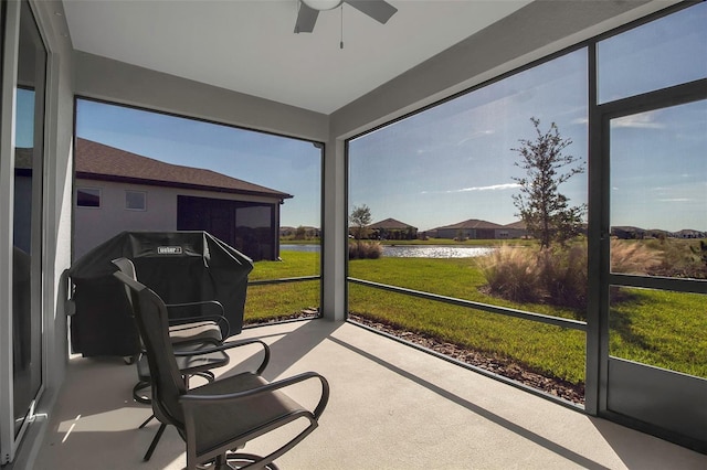 sunroom featuring a water view, a wealth of natural light, and ceiling fan