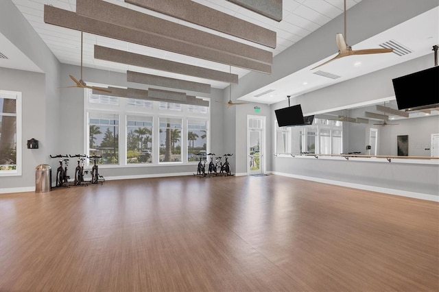 unfurnished living room featuring ceiling fan, hardwood / wood-style floors, and beamed ceiling