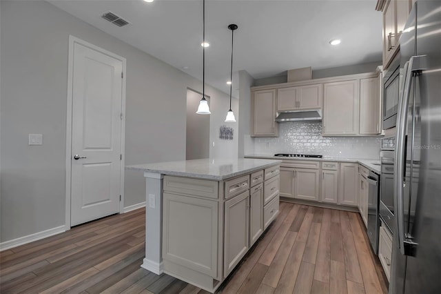 kitchen with decorative light fixtures, a center island, light stone counters, and wood-type flooring