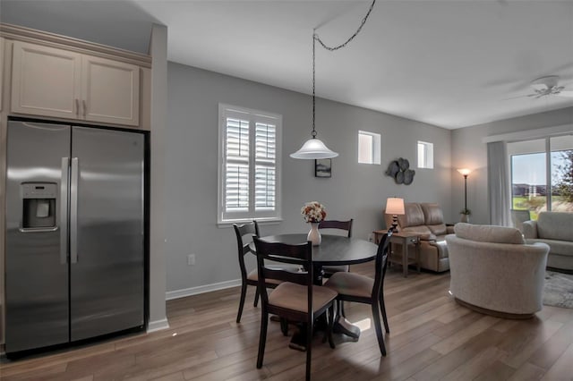 dining room featuring ceiling fan, a healthy amount of sunlight, and light hardwood / wood-style flooring